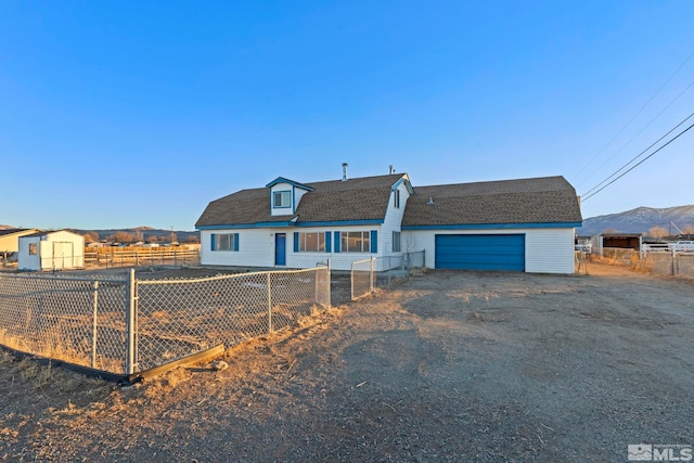 view of front of home featuring a mountain view and a storage shed