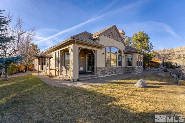 back of house featuring a patio and a lawn