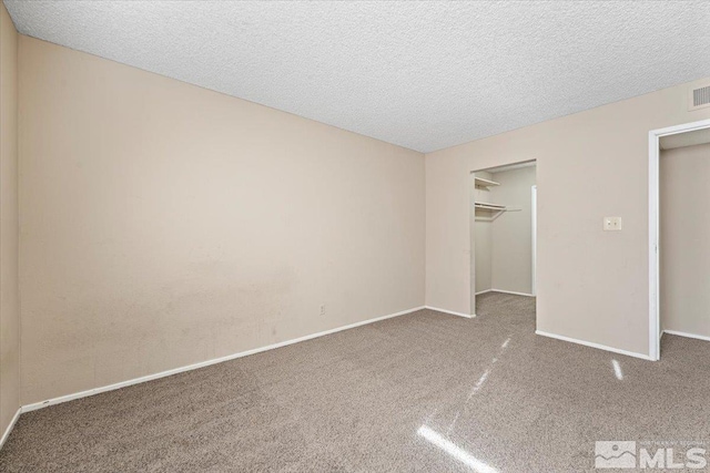 unfurnished bedroom featuring carpet flooring, a textured ceiling, and a closet