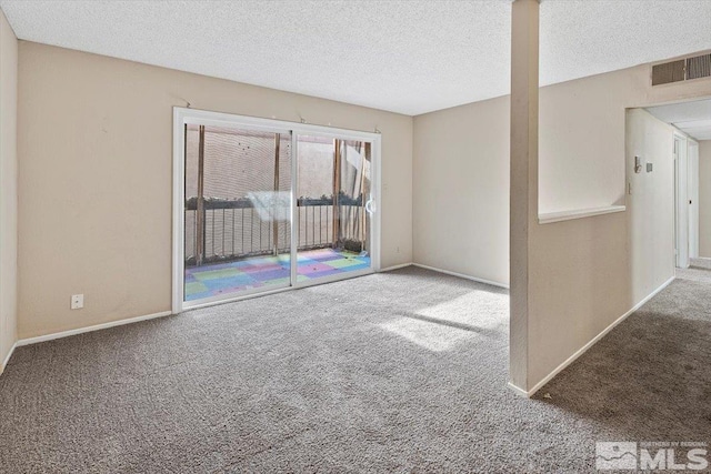 carpeted empty room with a textured ceiling