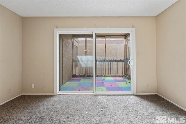 carpeted empty room featuring a textured ceiling