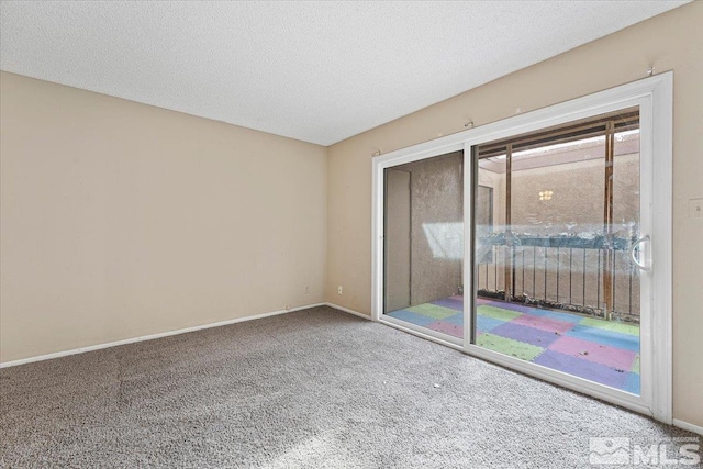 empty room with carpet floors and a textured ceiling