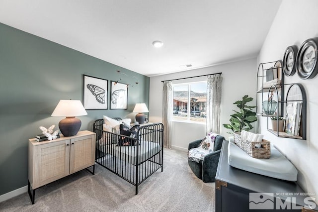 bedroom featuring carpet floors and a nursery area