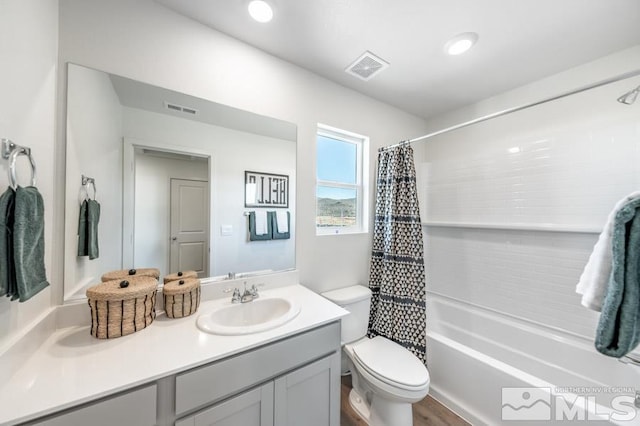 full bathroom with shower / tub combo, vanity, hardwood / wood-style flooring, and toilet