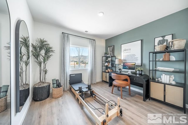 home office with light hardwood / wood-style flooring