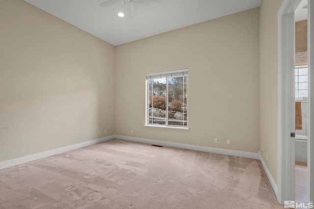 carpeted spare room featuring vaulted ceiling and ceiling fan