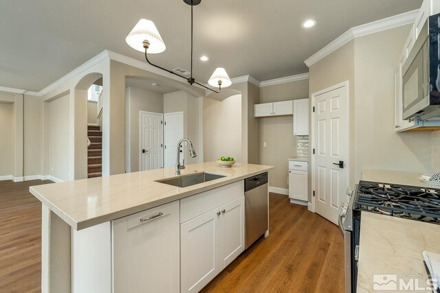 kitchen featuring appliances with stainless steel finishes, an island with sink, white cabinetry, and sink