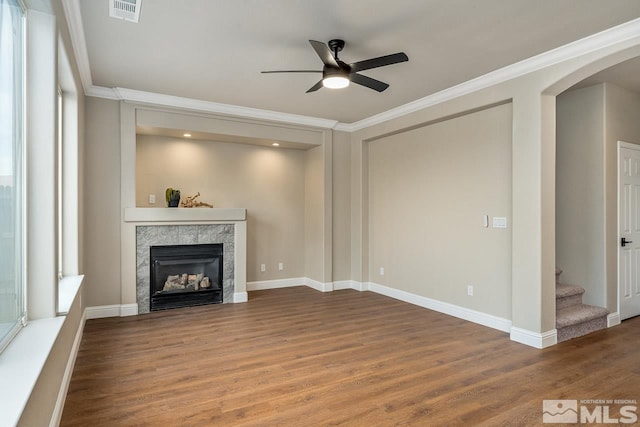 unfurnished living room featuring a fireplace, hardwood / wood-style floors, ceiling fan, and ornamental molding