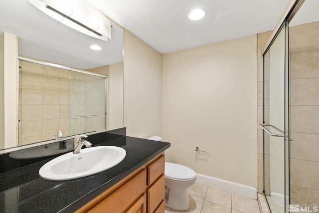 bathroom with tile patterned flooring, vanity, toilet, and a shower with door