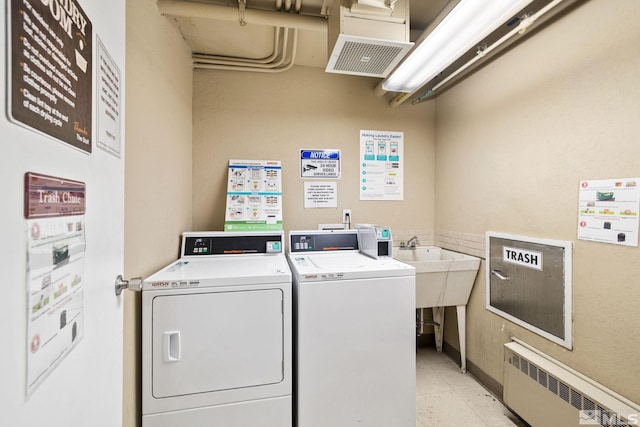 laundry area featuring washing machine and dryer and radiator heating unit