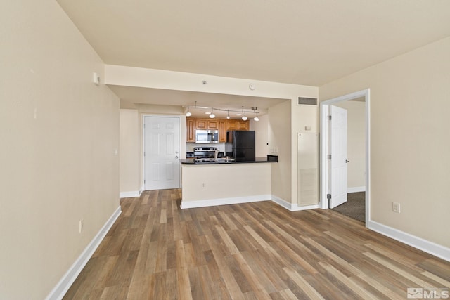 interior space with hardwood / wood-style floors, sink, and rail lighting