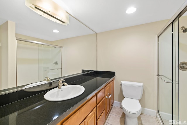 bathroom featuring tile patterned flooring, vanity, toilet, and walk in shower