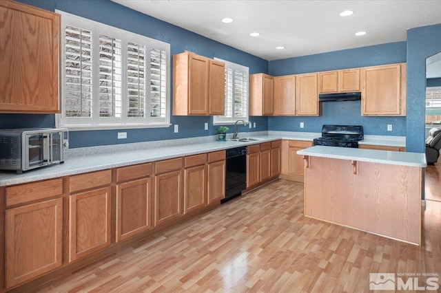 kitchen featuring light hardwood / wood-style flooring, a kitchen island, black appliances, and sink