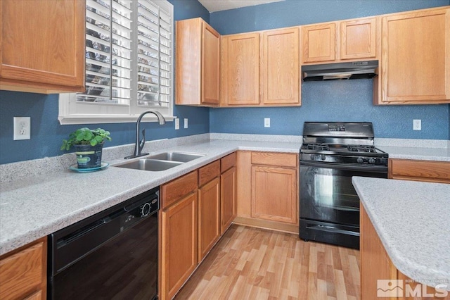 kitchen with light brown cabinets, sink, light hardwood / wood-style floors, and black appliances