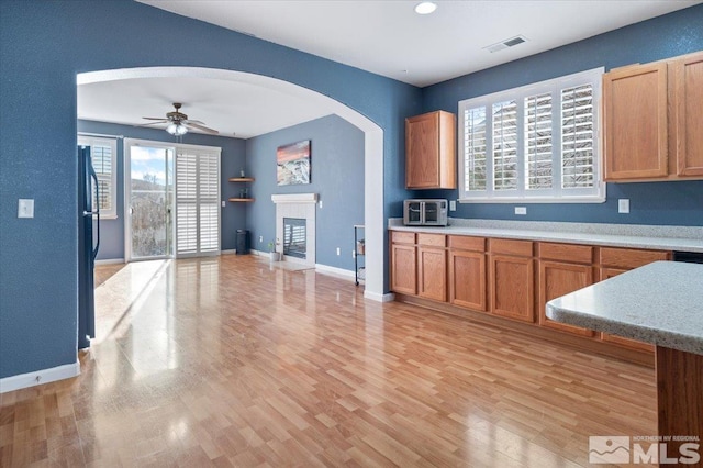 kitchen featuring black refrigerator, light hardwood / wood-style floors, and ceiling fan