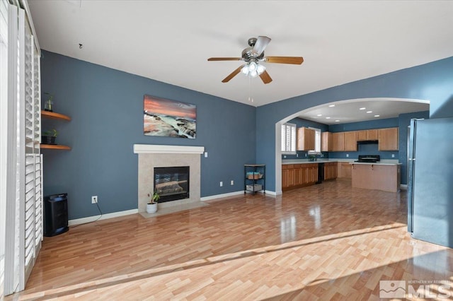 unfurnished living room featuring ceiling fan and light hardwood / wood-style floors