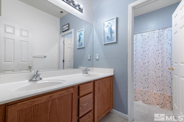 bathroom featuring curtained shower, tile patterned flooring, and vanity