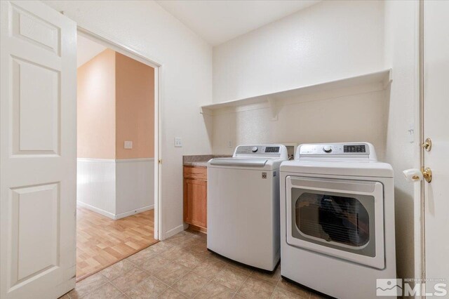 washroom featuring light hardwood / wood-style floors, cabinets, and separate washer and dryer