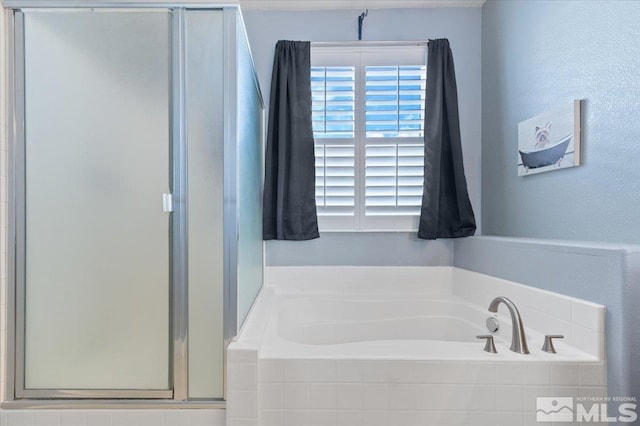 bathroom featuring separate shower and tub