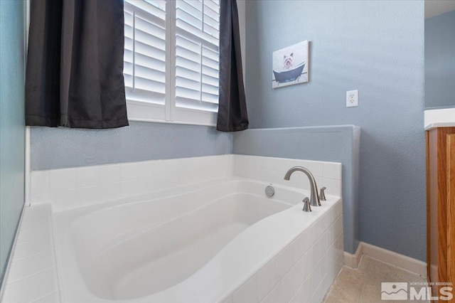 bathroom with tiled tub and tile patterned flooring