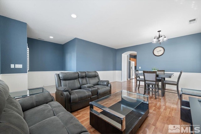 living room with light hardwood / wood-style flooring and a chandelier