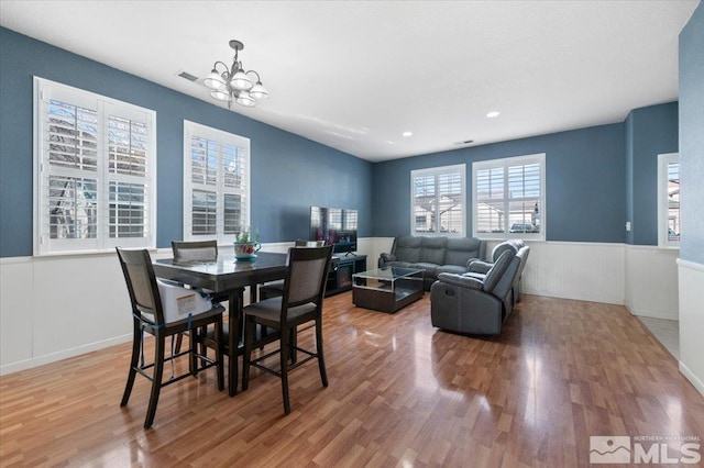 dining room featuring hardwood / wood-style floors, plenty of natural light, and an inviting chandelier