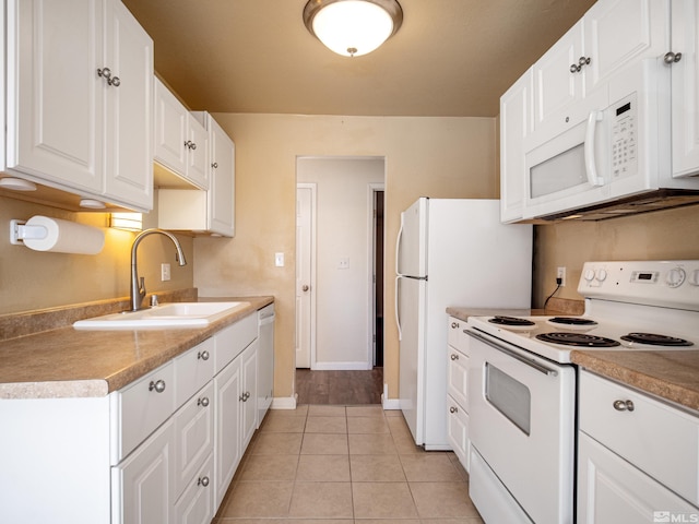 kitchen with sink, white cabinets, white appliances, and light tile patterned floors