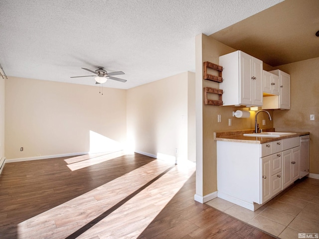 kitchen with a textured ceiling, ceiling fan, sink, light hardwood / wood-style flooring, and white cabinetry