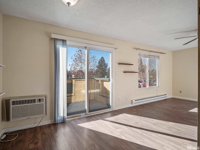 empty room with a wall mounted AC, hardwood / wood-style flooring, a wealth of natural light, and a baseboard heating unit