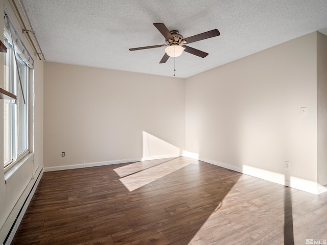 spare room featuring a textured ceiling, dark hardwood / wood-style floors, ceiling fan, and baseboard heating