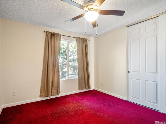 spare room with carpet, a textured ceiling, and ceiling fan