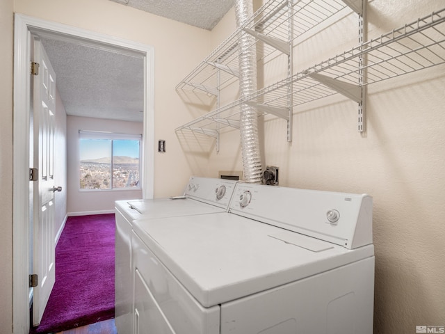 clothes washing area featuring carpet flooring, washer and dryer, and a textured ceiling