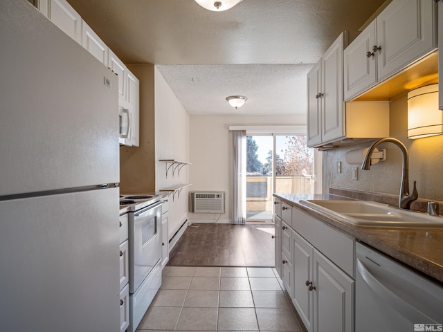 kitchen featuring white cabinets, white appliances, light hardwood / wood-style flooring, and sink