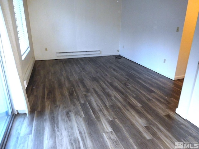 empty room with plenty of natural light, dark hardwood / wood-style floors, and a baseboard heating unit