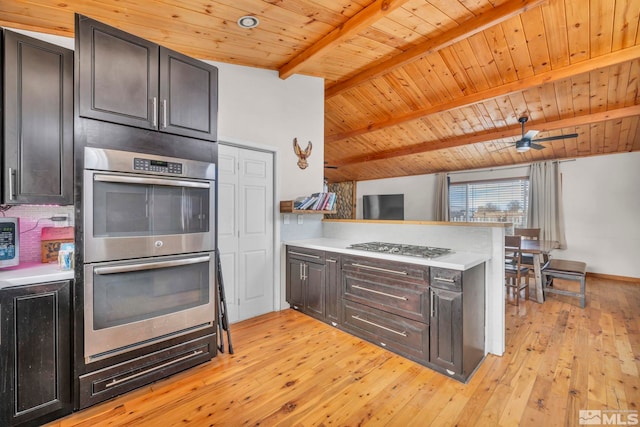 kitchen with lofted ceiling with beams, stainless steel appliances, light hardwood / wood-style flooring, and wood ceiling