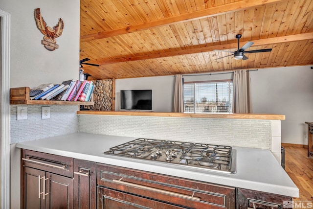 kitchen with tasteful backsplash, dark brown cabinetry, hardwood / wood-style floors, and stainless steel gas stovetop