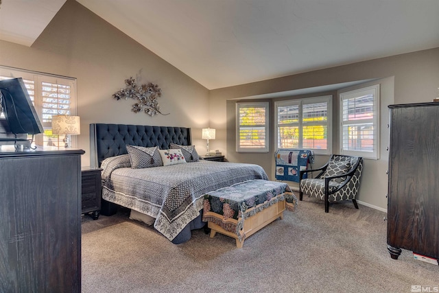 carpeted bedroom featuring multiple windows and lofted ceiling