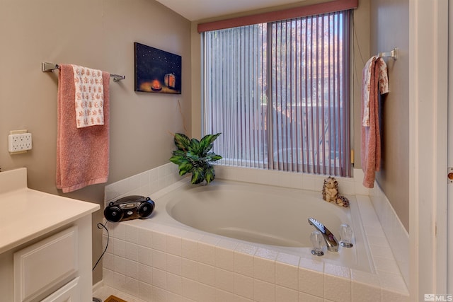 bathroom with vanity and a relaxing tiled tub