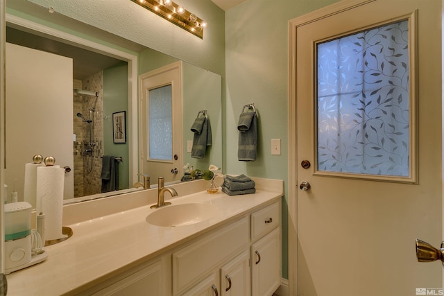 bathroom featuring vanity and tiled shower