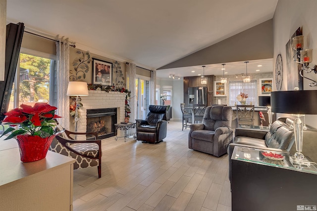 living room featuring light hardwood / wood-style floors, lofted ceiling, and a fireplace