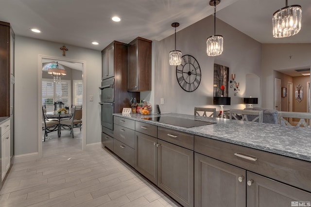 kitchen featuring an inviting chandelier, light stone counters, light hardwood / wood-style flooring, and vaulted ceiling