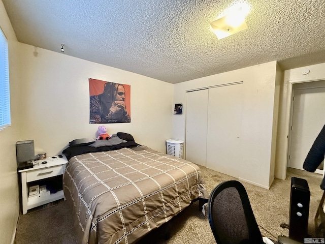 carpeted bedroom with a textured ceiling and a closet