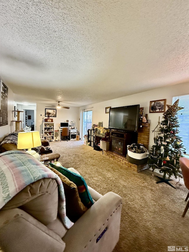 living room featuring carpet flooring, a textured ceiling, and ceiling fan