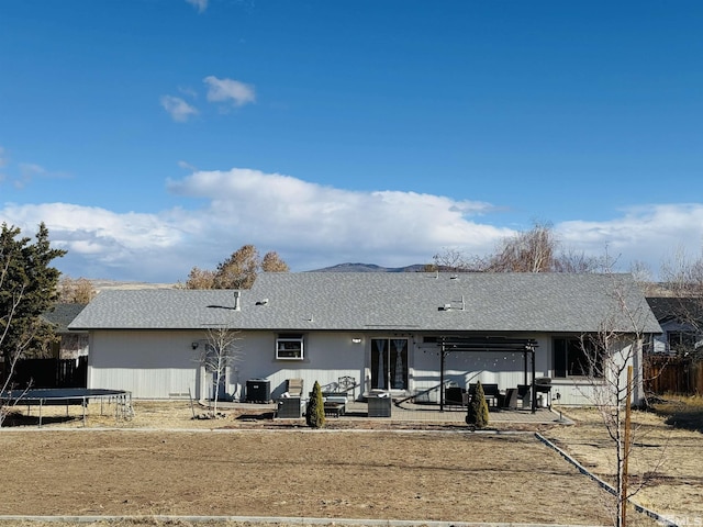 rear view of property with an outdoor hangout area, a trampoline, and a patio area