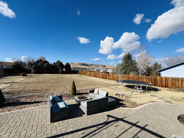 view of yard with outdoor lounge area, a trampoline, and a patio