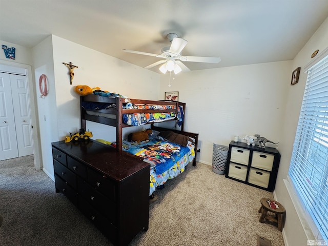 carpeted bedroom featuring ceiling fan and a closet