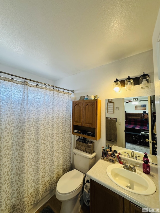 bathroom with a shower with curtain, ceiling fan, toilet, and vanity