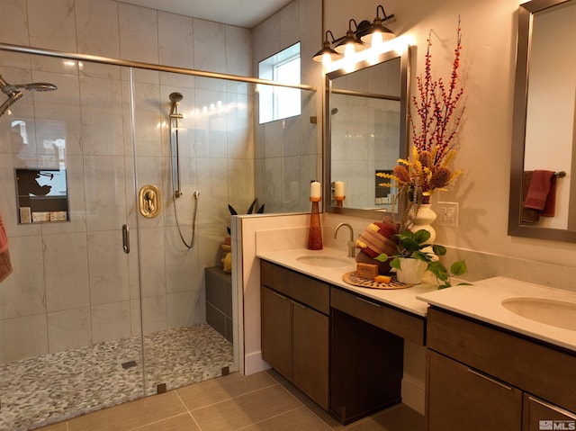 bathroom featuring double vanity, a shower stall, a sink, and tile patterned floors