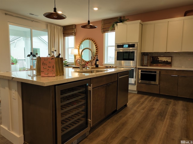 kitchen with beverage cooler, light countertops, hanging light fixtures, and white cabinetry