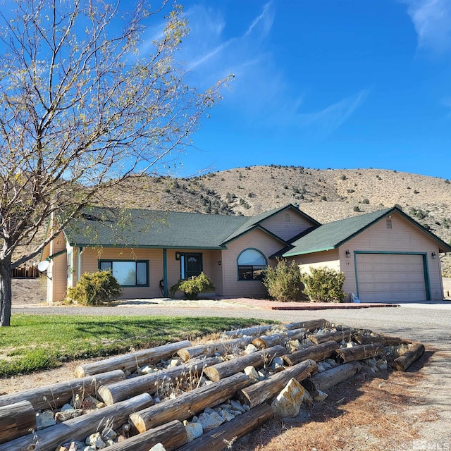 ranch-style home with a mountain view and a garage